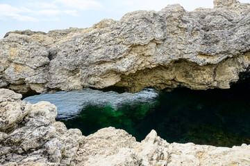 Cape Tarkhankut on the Crimean peninsula. The rocky coast of the Dzhangul Reserve in the Crimea. The Black Sea. Turquoise sea water. Rocks and grottoes of Cape Tarkhankut.