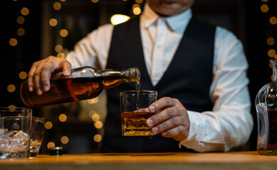 Barman pouring whiskey whiskey glass..