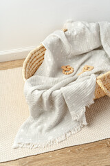 Muslin blanket and wooden toys in baby cradle