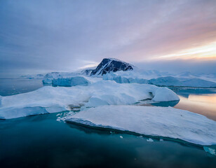Antarctic landscape with icebergs and ice floes at sunset
