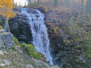 A beautiful waterfall in the autumn mountains beyond the Arctic Circle in the north, in Khibiny,...