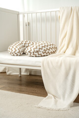 White wooden baby crib with pillow in nursery room - obrazy, fototapety, plakaty