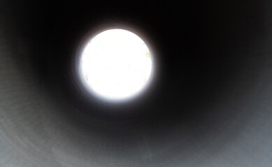 Looking through long round concrete pipe