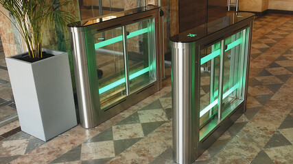 Automatic Security gateway and electronic card reader. Electronic card reader at office security gate. Automatic security turnstiles with card reader in a corporate office building