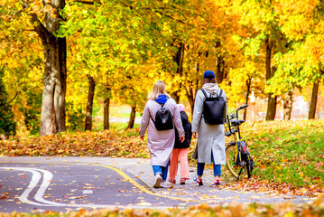 Two girls walking in the autumn park
