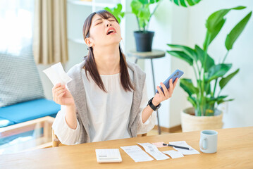 レシートを手に驚いた表情をする若い女性