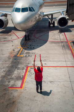 Marshaller directing commercial airliner to park at terminal