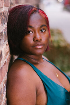 Female black model facial portrait of girl by brick building