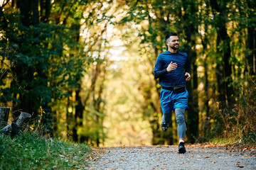 Obraz premium Full length of sportsman running through park.