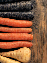 Three different root vegetables on a rustic wooden table