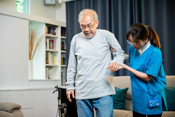 Asian doctor support old man to getting up to exercise, help handicapped elderly stand up, woman...