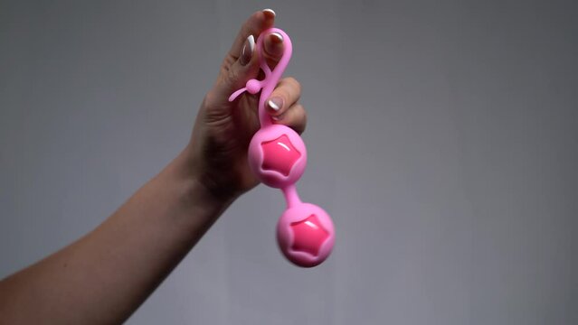 female hand holding a vaginal eggs isolated on white background.