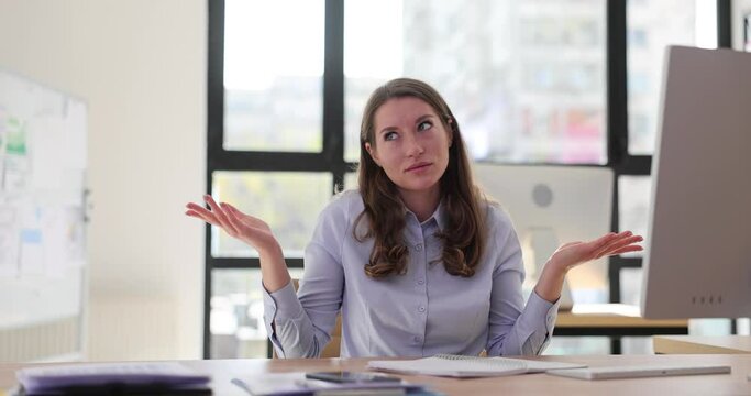 Confused unsure woman shrugging shoulders in office