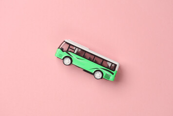 Toy bus miniature on a pink background.Travel concept