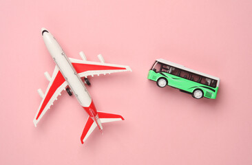 Toy bus miniature and air plane on a pink background.Travel concept