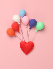 Miniature air balloons and heart on a pink background. Birthday, love concept