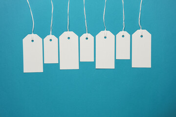 Set of blank white tags with ropes on blue background. Mock up, Template for design. Copy space. Sale, shopping concept