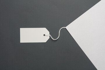 A4 sheet of paper with tag on string on dark gray background. Template for design