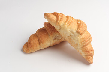 Two appetizing croissants on a white background