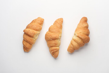 Three appetizing croissants on a white background