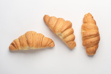 Three appetizing croissants on a white background