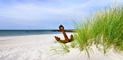 Baltic Sea Beach with rusty Anchor - Panorama with Sun and cloudy Sky