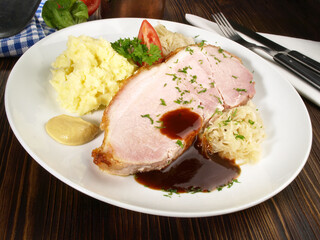 Schweinebraten mit Sauerkraut, Kartoffelpüree, Senf und Bratensauce