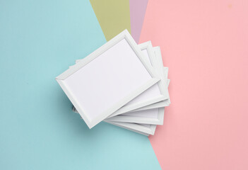 Stack of white photo frames on colorful pastel background