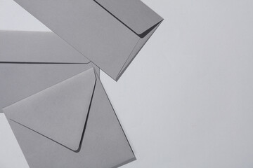 Gray envelopes on gray background. Minimalism, modern business still life, creative layout