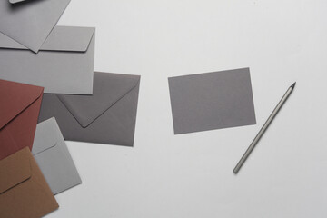 Floating envelope with card and pencil on gray background. Minimalism, modern business still life,...