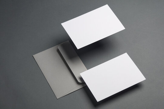 Floating envelope and cards on dark gray background with shadow. Minimalism, modern business still life, creative layout