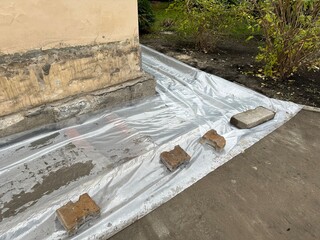 Poured foundation covered with membrane. Liquid cement dries under plastic membrane