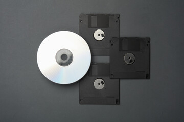 Retro storage media. CD disk and floppy disks on a dark background