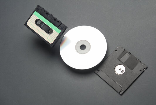 Retro storage media. Audio cassette, CD and floppy disk on a dark background