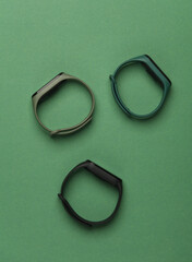 Three smart bracelets on a green background