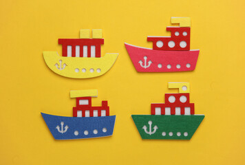 Toy ships made of felt on a yellow background. Travel concept