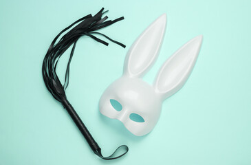 Sex shop toys. Rabbit mask with leather whip on blue background - obrazy, fototapety, plakaty