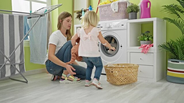 Caucasian mother and daughter seriously concentrate on washing toys in the laundry room, a picture of family housekeeping