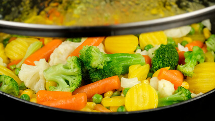 Colorful steaming vegetables frying on a pan. Healthy food, vegetarian cuisine