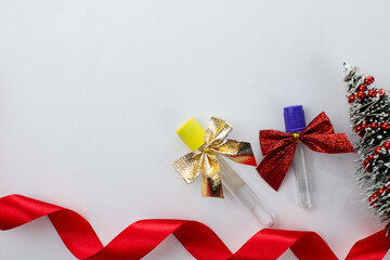 Christmas in laboratory. Medical test tubes with christmas bows and christmas tree on background
