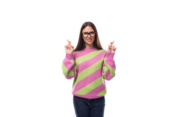 young brunette woman crossed her fingers in hope on a white background with copy space