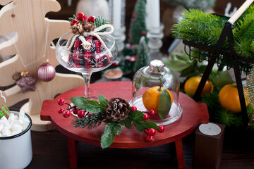 A glass of champagne and tangerines on the table. Christmas and New Year background decorated with Christmas trees