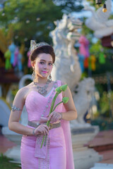 Beautiful portrait fashion of an Asian woman wearing an Elegant Thai dress wedding costume which is popular according to Thai culture at Wat Pa Dara Phirom Temple in Chiang Mai, Thailand.