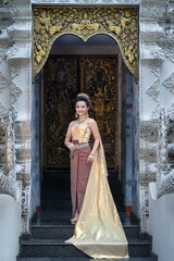 Beautiful portrait fashion of an Asian woman wearing an Elegant Thai dress wedding costume which is popular according to Thai culture at Wat Pa Dara Phirom Temple in Chiang Mai, Thailand.