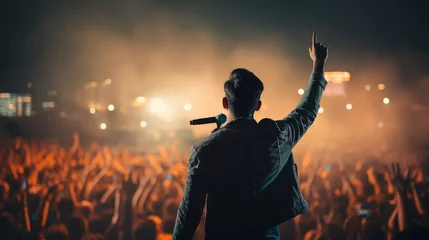 Foto op Aluminium Unrecognizable singer male standing on stage in concert with crowd of people, live music with audience hold smartphone taking picture, musician man on tour with spot light in city night background © Rakchanika