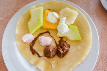 tasty breakfast with pancake fruits and nougat creme on vacation