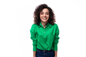 Fototapeta premium young bright smiling european brunette woman with curly styling in a green shirt works in an advertising agency