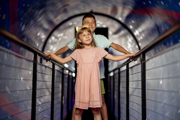 Little boy and girl in a room that shows the universe and gravity, visiting science museum. Concept...