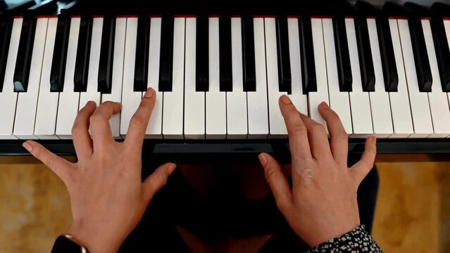 Kids hands playing piano closeup, typing chords with the keys. Teaching music