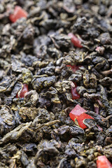 Dried natural large tea leaves close up. Chinese tea Tie Guan Yin with strawberry pieces. 